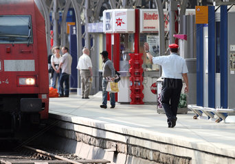 Koeln  Deutschland  Schaffner winkt einem Zug hinterher