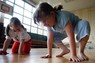 Uebergewichtige Kinder beim Sport mit Physiotherapeutin.
