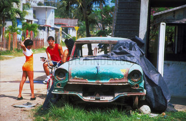 Kubaner stehen an einem alten Auto auf der Strasse
