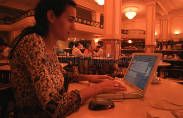 Frau im Cafe vor einem Laptop