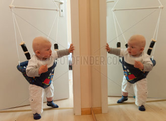 Freiburg  Deutschland  ein Baby im Babyhopser vor einem Spiegel