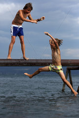 Bolsena  Italien  Junge schubst seinen kleinen Bruder von einem Steg ins Meer