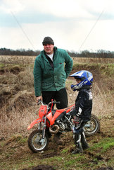 Vater mit seinem Sohn vor dem Motocross-Fahren  Norddeutschland