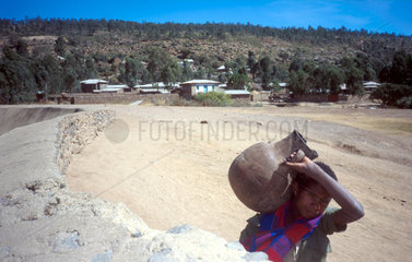 Ein Kind traegt einen Krug zum Brunnen (Aethiopien)
