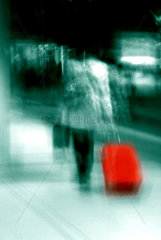 Berlin  eine Frau mit einem roten Koffer am Bahnsteig