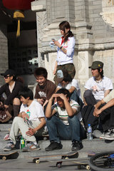 Peking  Jugendliche schauen Skateboardfahrern zu
