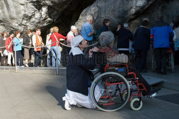 Glaeubige beten an der Grotte von Massiabelle in Lourdes  Frankreich