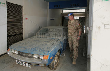 Nikosia  Zypern  ein verstaubtes Auto im Maple House  daneben ein UN-Soldat