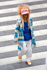 Tokio  Japan  Shibuya  extravagant gekleideter junger Mann ueberquert eine Strasse