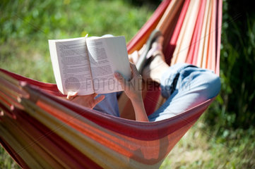 Vacqueyras  Frankreich  eine Frau liest und liegt entspannt in einer Haengematte
