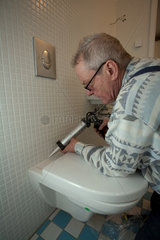 Berlin  Deutschland  ein Handwerker arbeitet an einer Toilette