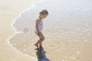 Little girl wading in the surf