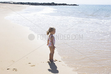 Little girl staring at the sea