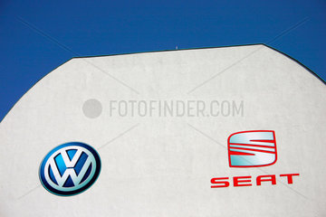 Berlin - VW und Seat Firmenlogo vor einem Autohaendler