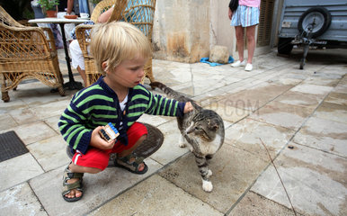 Santanyi  ein kleiner Junge streichelt eine Katze