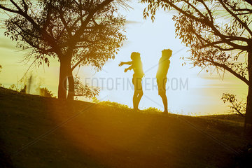 Couple enjoying nature  silhouetted by sun