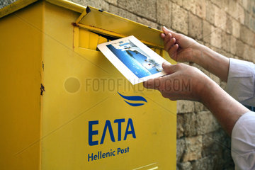 Rhodos  einwerfen einer Ansichtskarte in einen Briefkasten der Hellenic Post