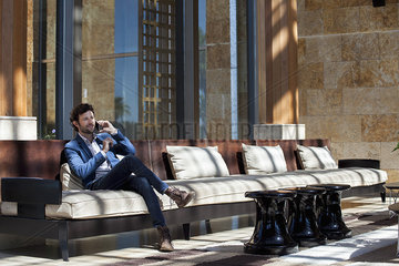 Man talking on cell phone in lobby
