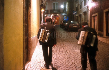 Musiker laufen durch das naechtliche Lissabon
