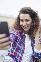 Young woman using smartphone to take a selfie