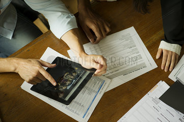 Colleagues using digital tablet during meeting