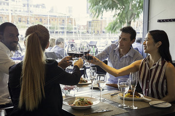 Friends clinking wine glasses in restaurant