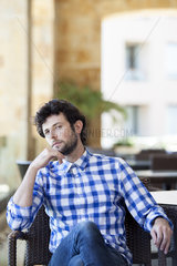 Man sitting with thoughtful expression on face