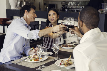 Couple clinking glasses in restaurants with friends