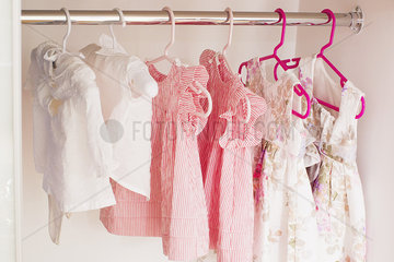 Baby clothes hanging in closet