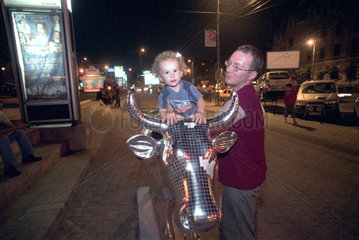 Kleines Maedchen sitzt auf einer Skulptur der CowParade Bucharest 2005