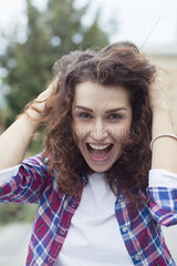 Carefree young woman laughing outdoors  portrait