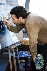Artist working on oil painting in art studio