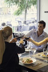 Friends clinking wine glasses in restaurant