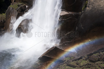 Rainbow at the base of a waterfall in Yosemite National Park  California  USA
