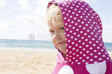 Girl wearing hood with polka dots at beach