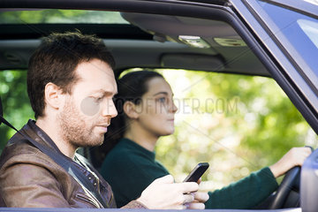 Man reading text messages while riding in car
