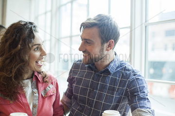 Cheerful couple talking together in coffee shop