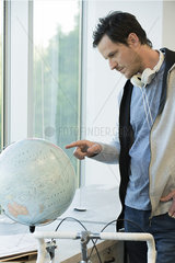Man looking at globe