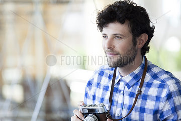 Man holding camera and smiling