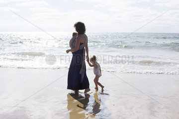 Mother and children walking on beach