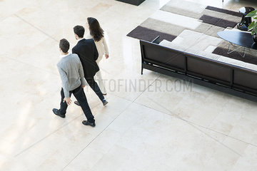 Business associates walking together in office lobby