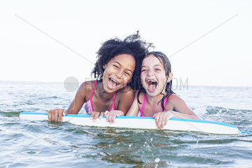 Girls playing with body board in water