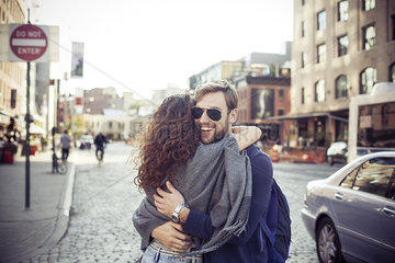 Couple embracing on city street