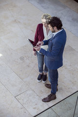 Couple using digital tablet together outdoors