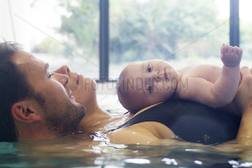 Parents with infant in swimming pool
