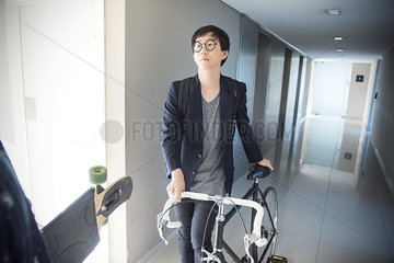 Man walking with bicycle in corridor