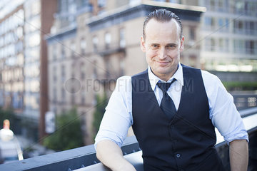 Businessman on balcony  smiling  portrait