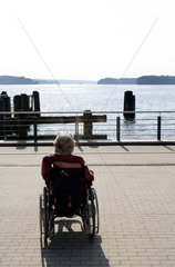 Bad Saarow  eine aeltere Frau im Rollstuhl geniesst den Ausblick auf den Scharmuetzelsee