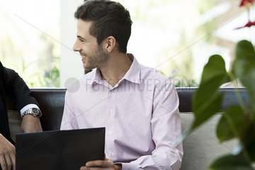 Businessman showing laptop to colleague