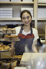 Woman working behind bakery counter  portrait
